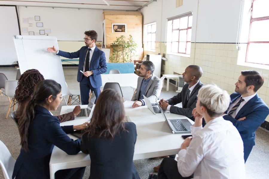 Illinois Sexual Harassment Training - Group of Business Professionals Actively Engaged in a Team Training in a Modern Office Setting